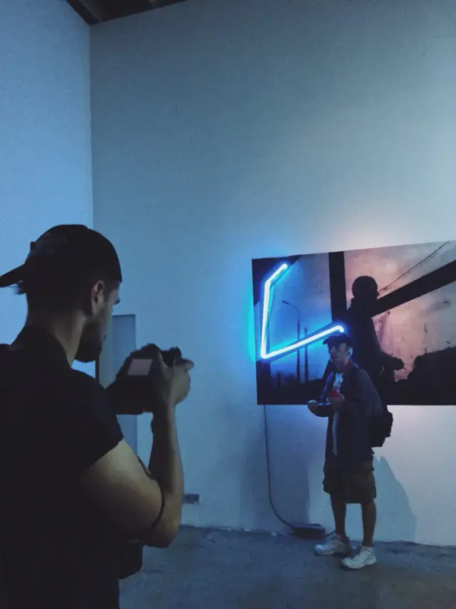 Alexey filming a performer in a blue-lit room