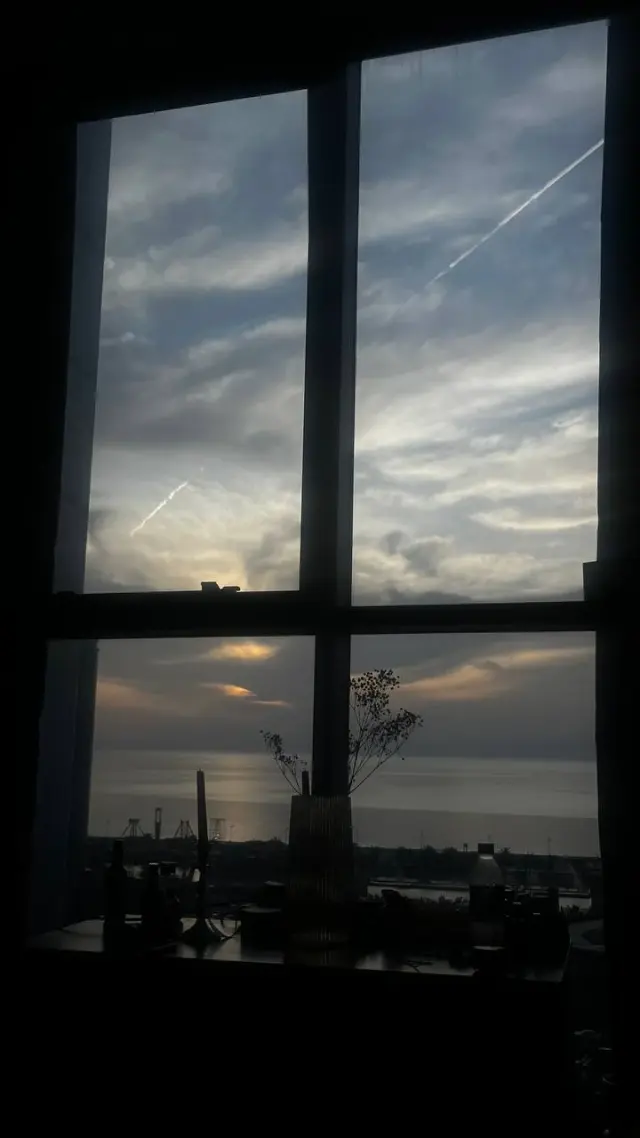 Evening clouds seen through a dark window