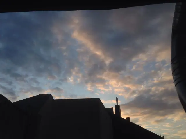 Evening clouds above a dark rooftop