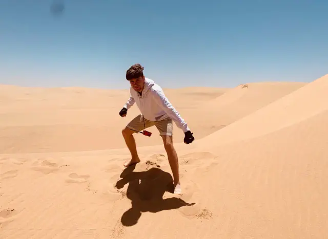 Alexey standing on a sand dune