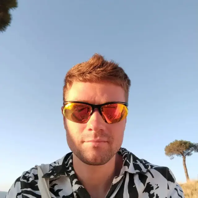 Alexey in a patterned shirt and mirrored sunglasses outdoors
