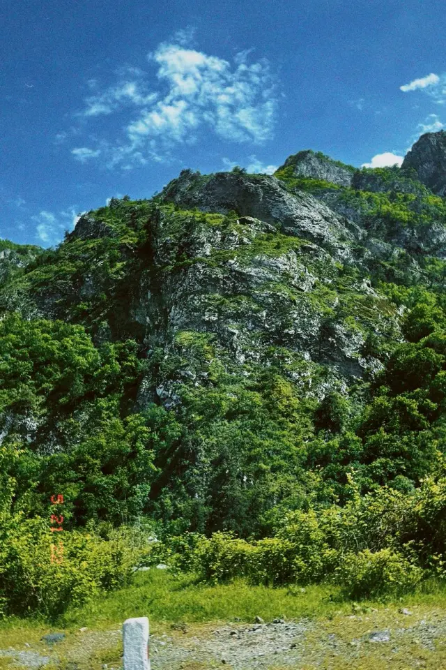 Green mountain slopes beneath a blue sky