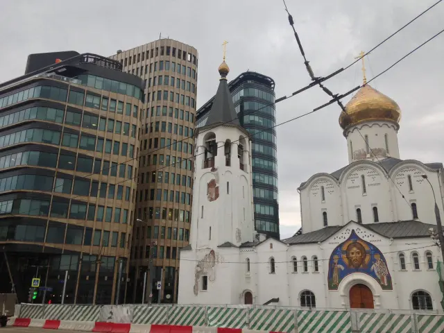 A church with golden domes beside modern buildings
