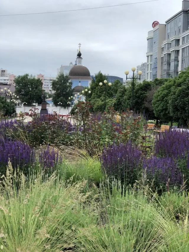 A flower garden in front of a domed building