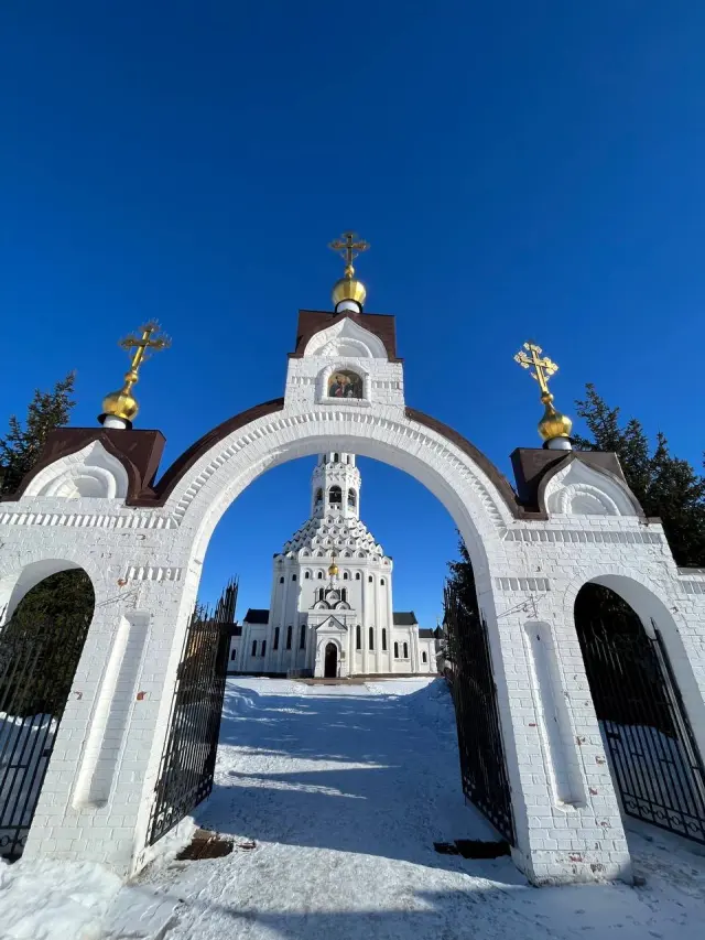 A white ornamental arch beneath a blue sky