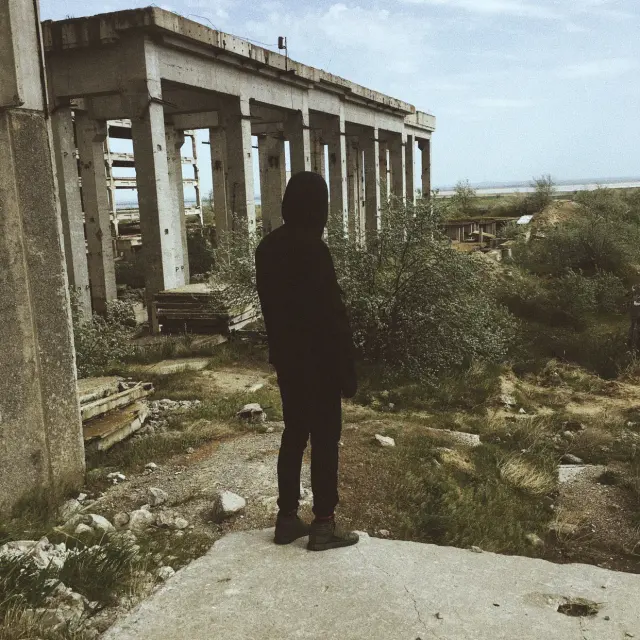 A person standing among concrete ruins