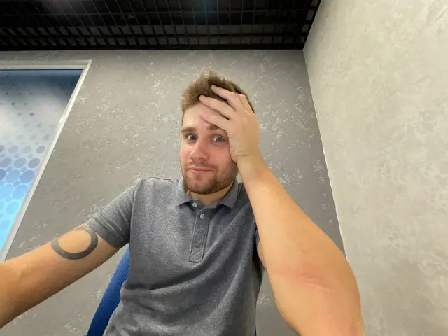 Alexey seated at a desk with his hand in his hair