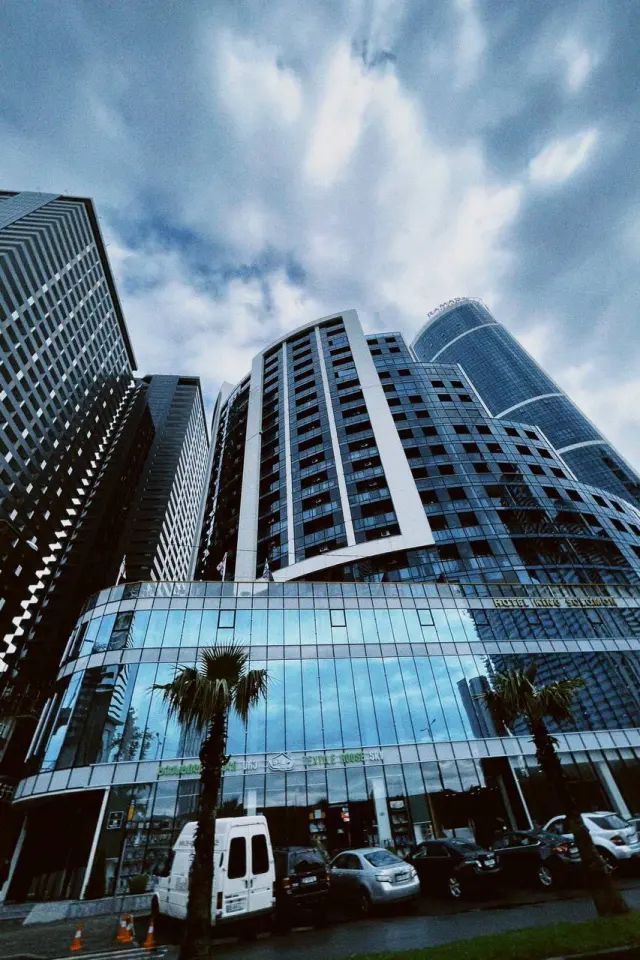 Modern high-rise buildings beneath streaks of cloud